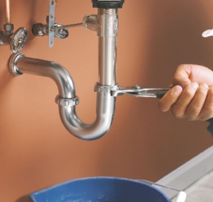 Plumber using wrench to tighten water pipes